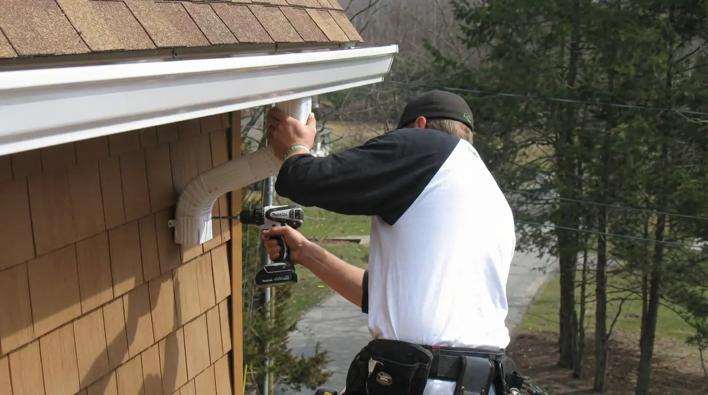 Professional contractor installing tan vinyl siding panels on a residential home exterior in Pembroke Pines, FL